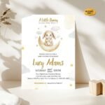 Neutral baby shower invitation with bunny on the moon design in a soft beige setting.