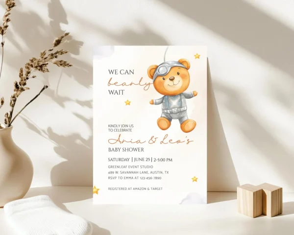 Neutral Tone: Astronaut teddy bear baby shower invitation card on a white table.